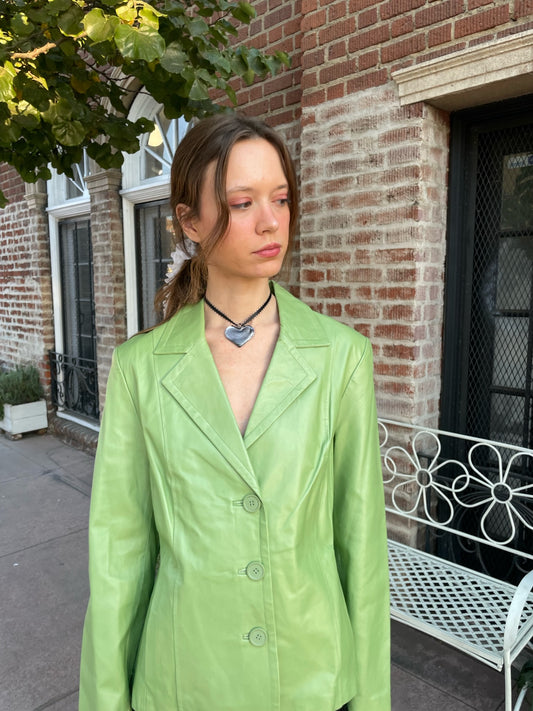 girl wearing shiny green blazer and black skirt