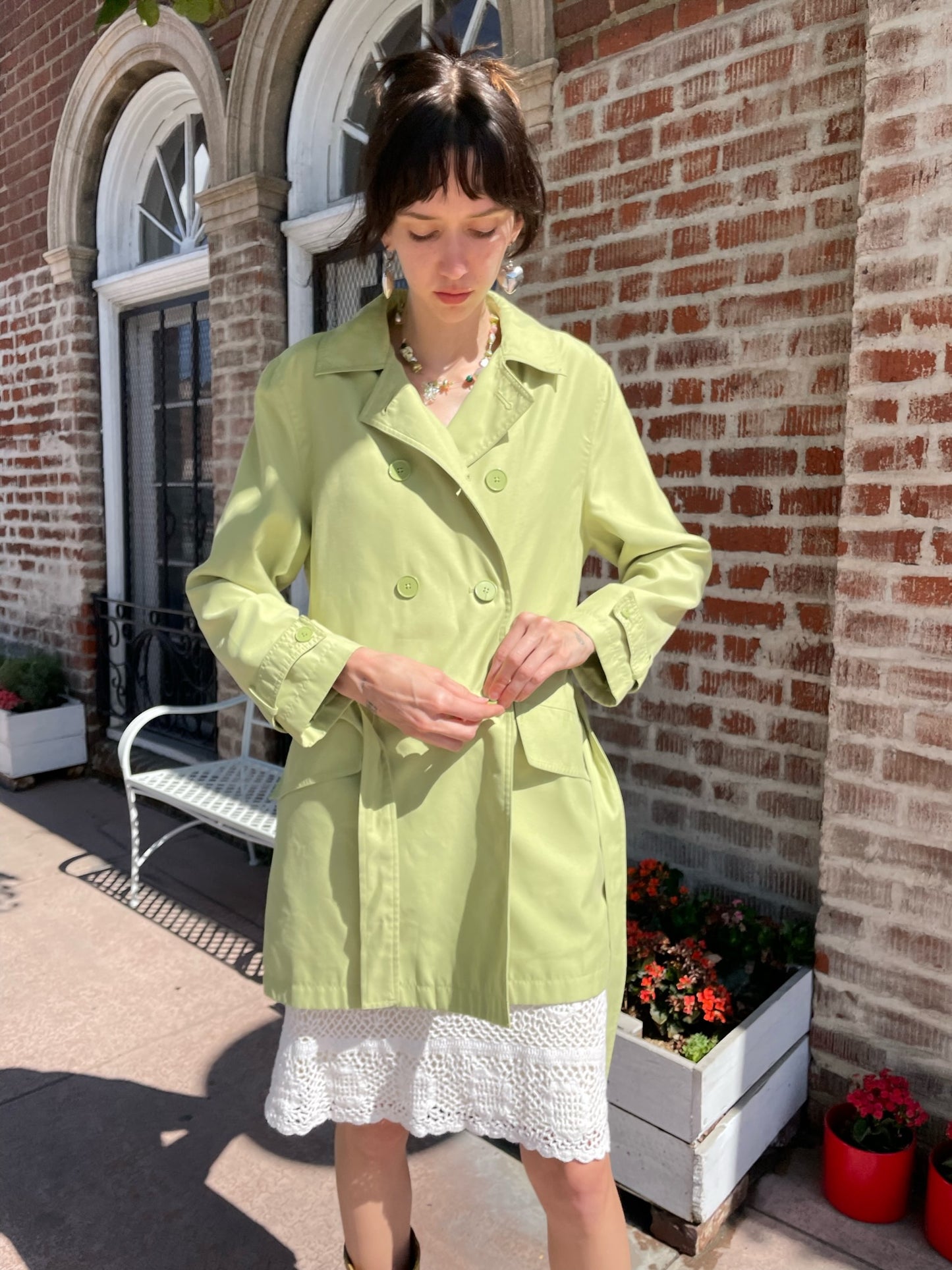 girl wearing light green pea coat and white skirt