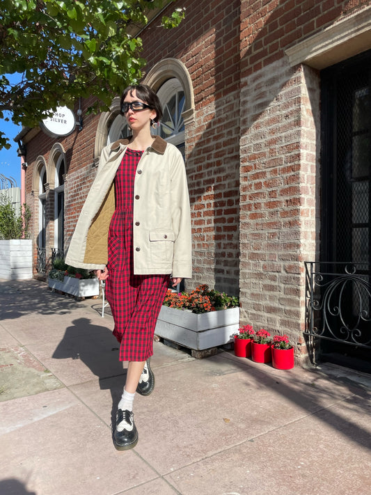 girl wearing a red dress and a tan jacket