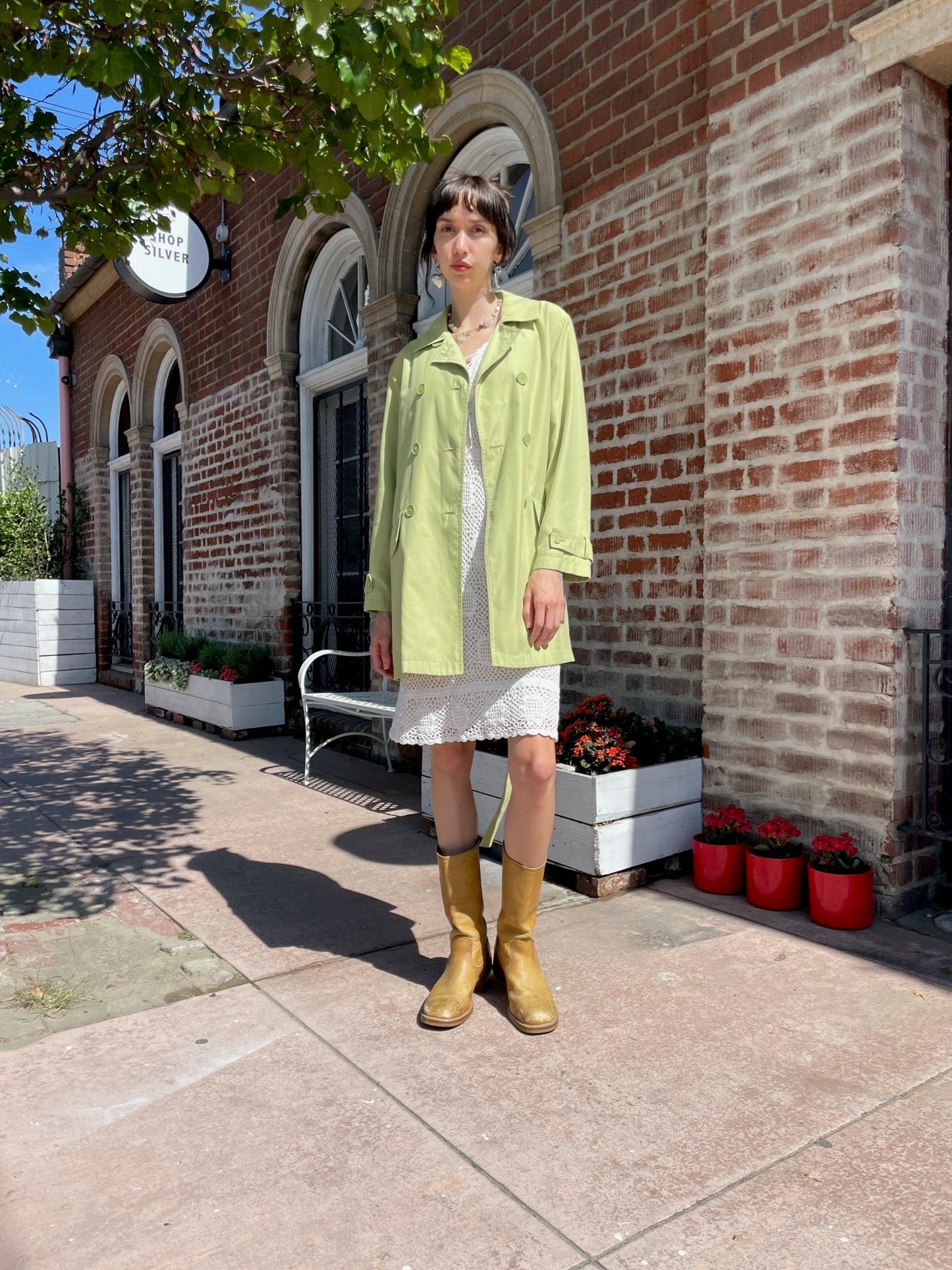 girl wearing light green pea coat and white skirt
