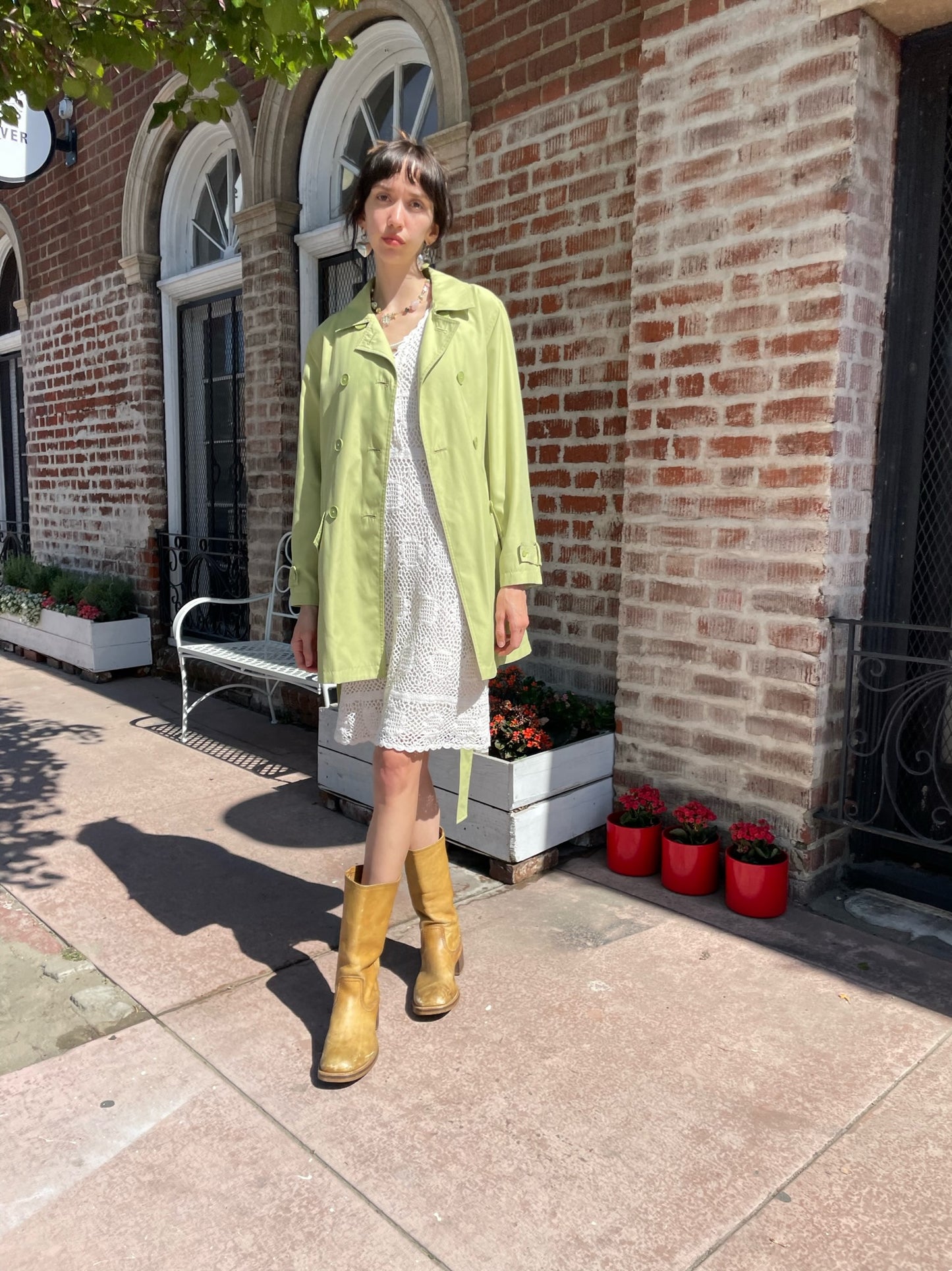 girl wearing light green pea coat and white dress