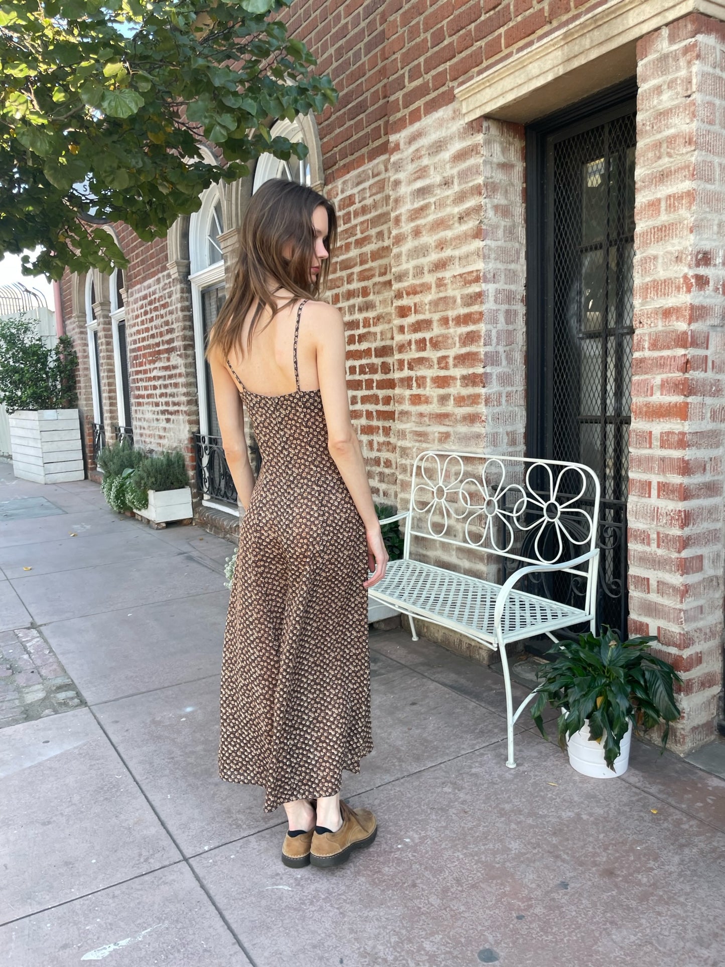 back of girl wearing brown dress and brown shoes