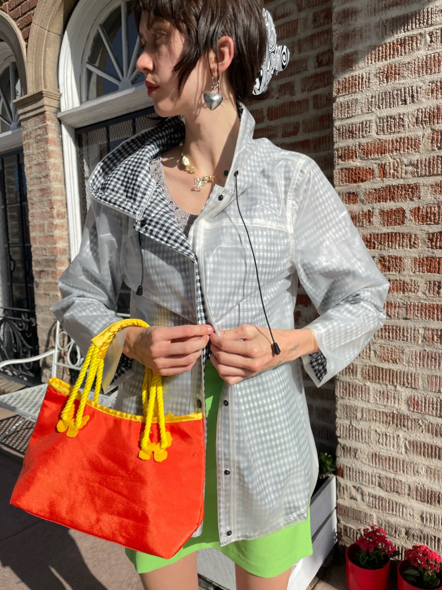 girl wearing gingham rain jacket, rhinestone tank top and bright green skirt