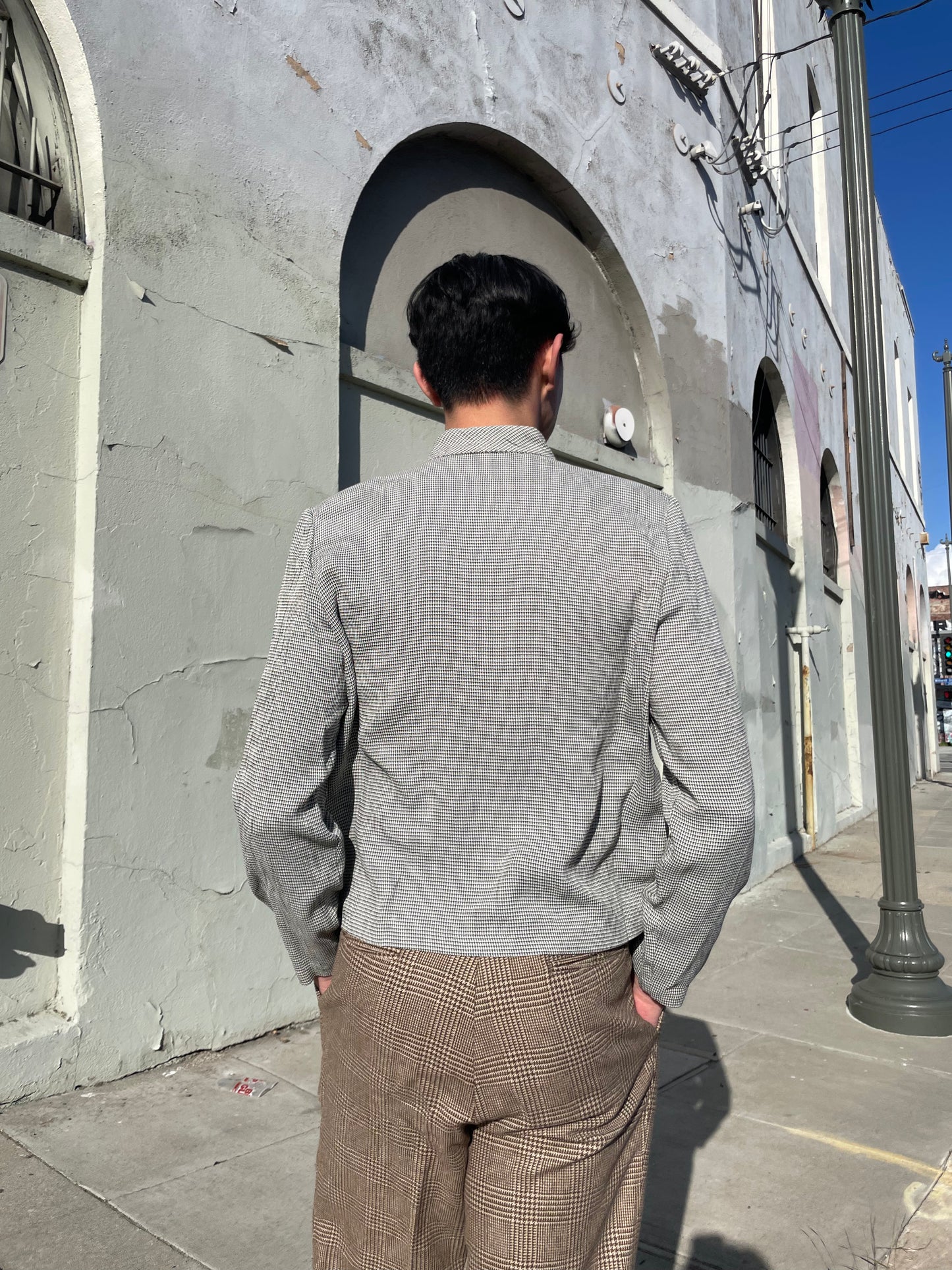 back of boy wearing grey jacket and tan slacks