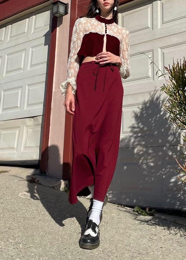 girl wearing red and white lace top and long red skirt