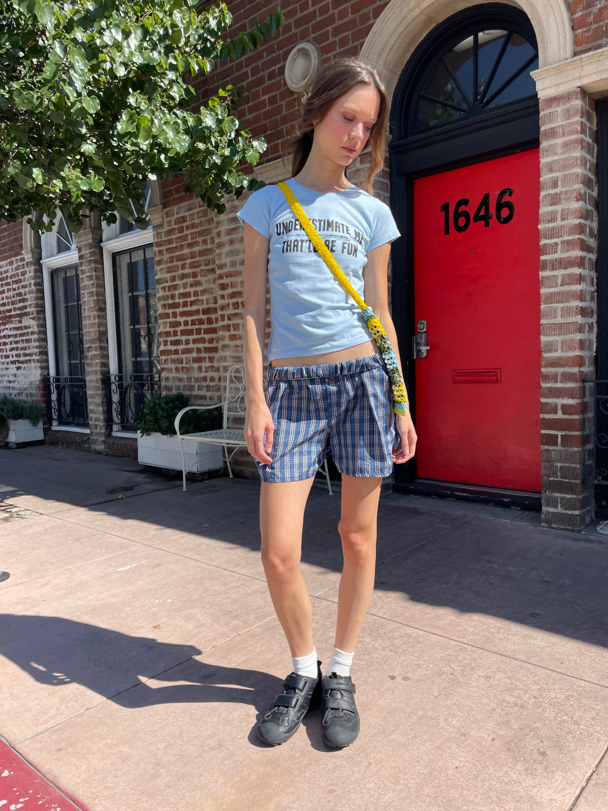 girl in blue t-shirt and plaid shorts