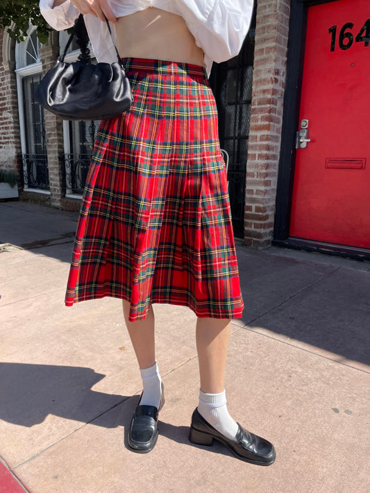 girl in white button up and plaid red skirt