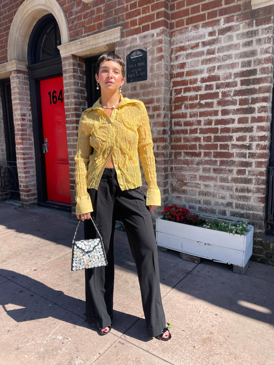 girl wearing gold top and black trousers