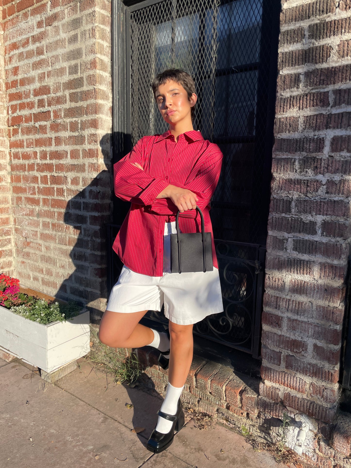 girl wearing red button down shirt and white shorts