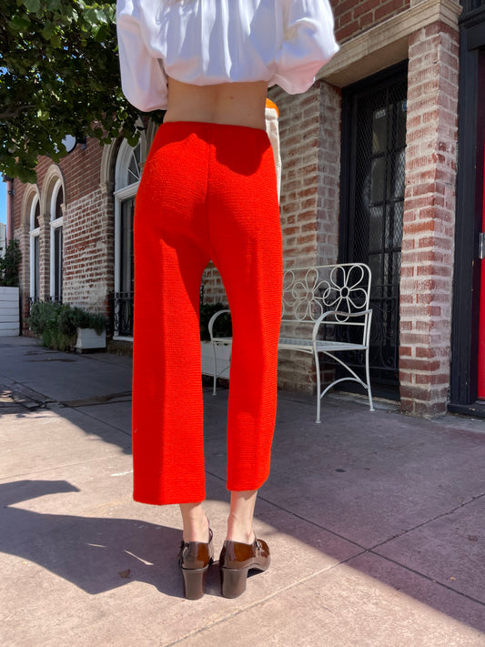 girl in white long sleeve button up and orange pants