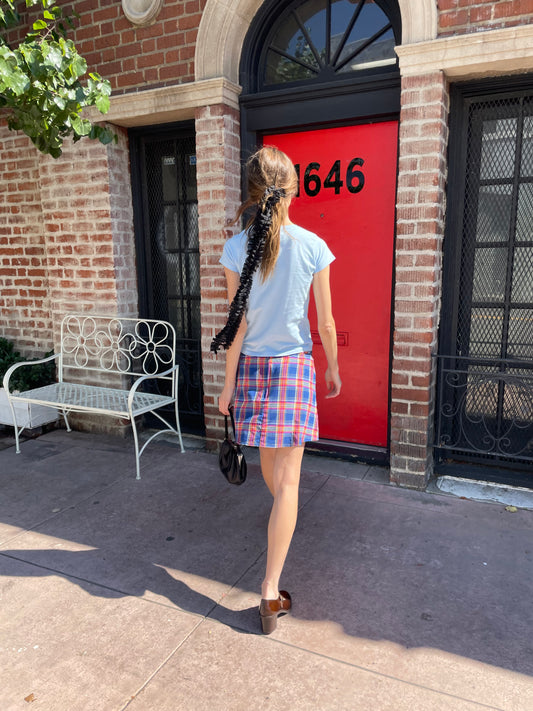 girl in blue t-shirt and plaid skirt