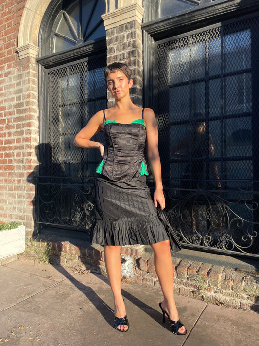 girl in black skirt and black and green top