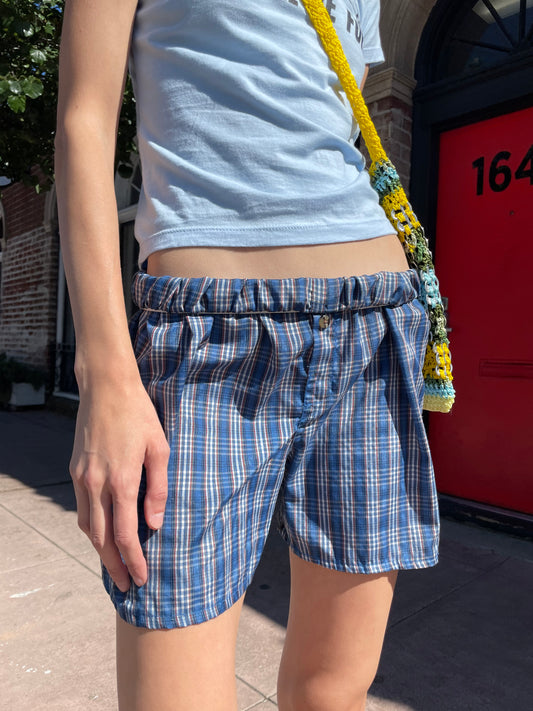 girl in blue t-shirt and plaid shorts