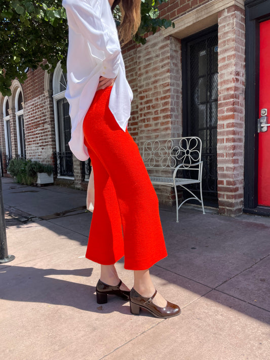 girl in white long sleeve button up and orange pants