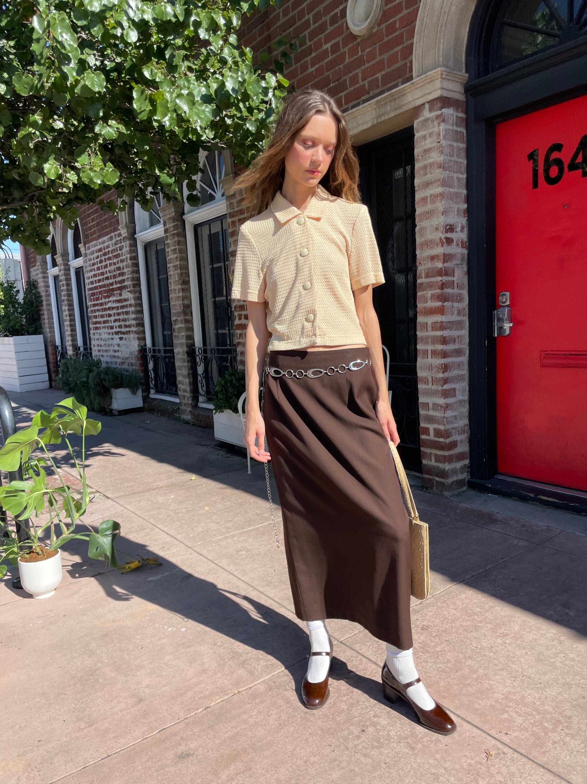 girl in yellow top and brown skirt