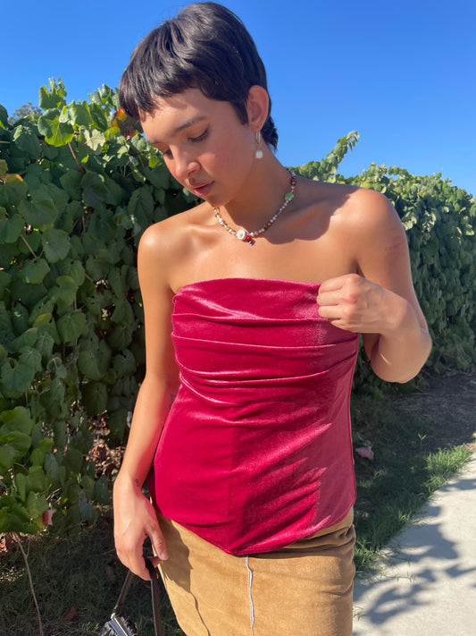 girl wearing pink velvet corset and tan skirt