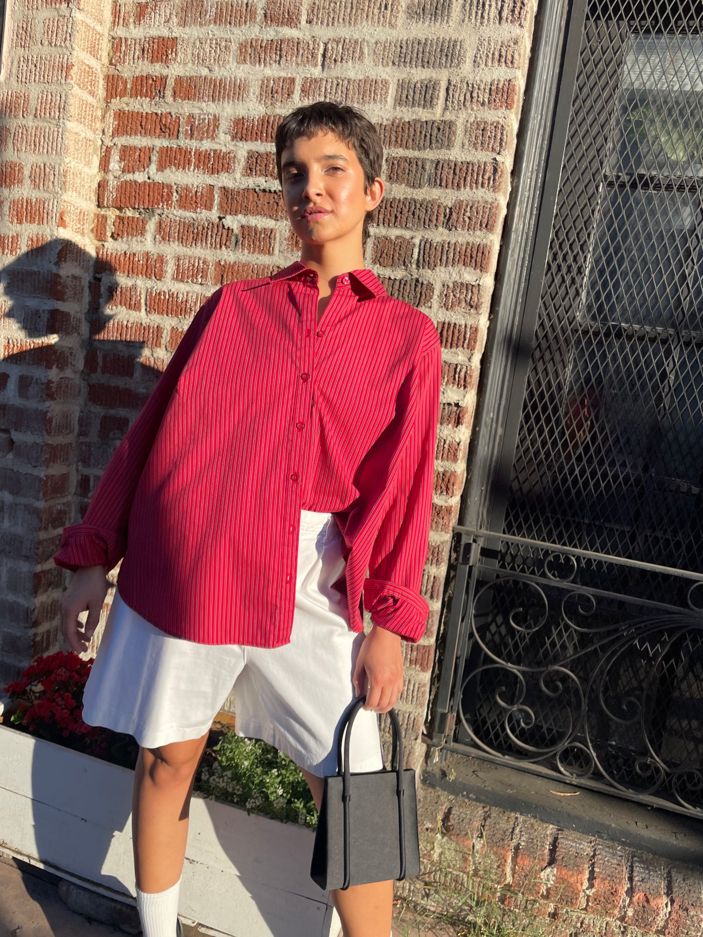 girl wearing red button down shirt and white shorts