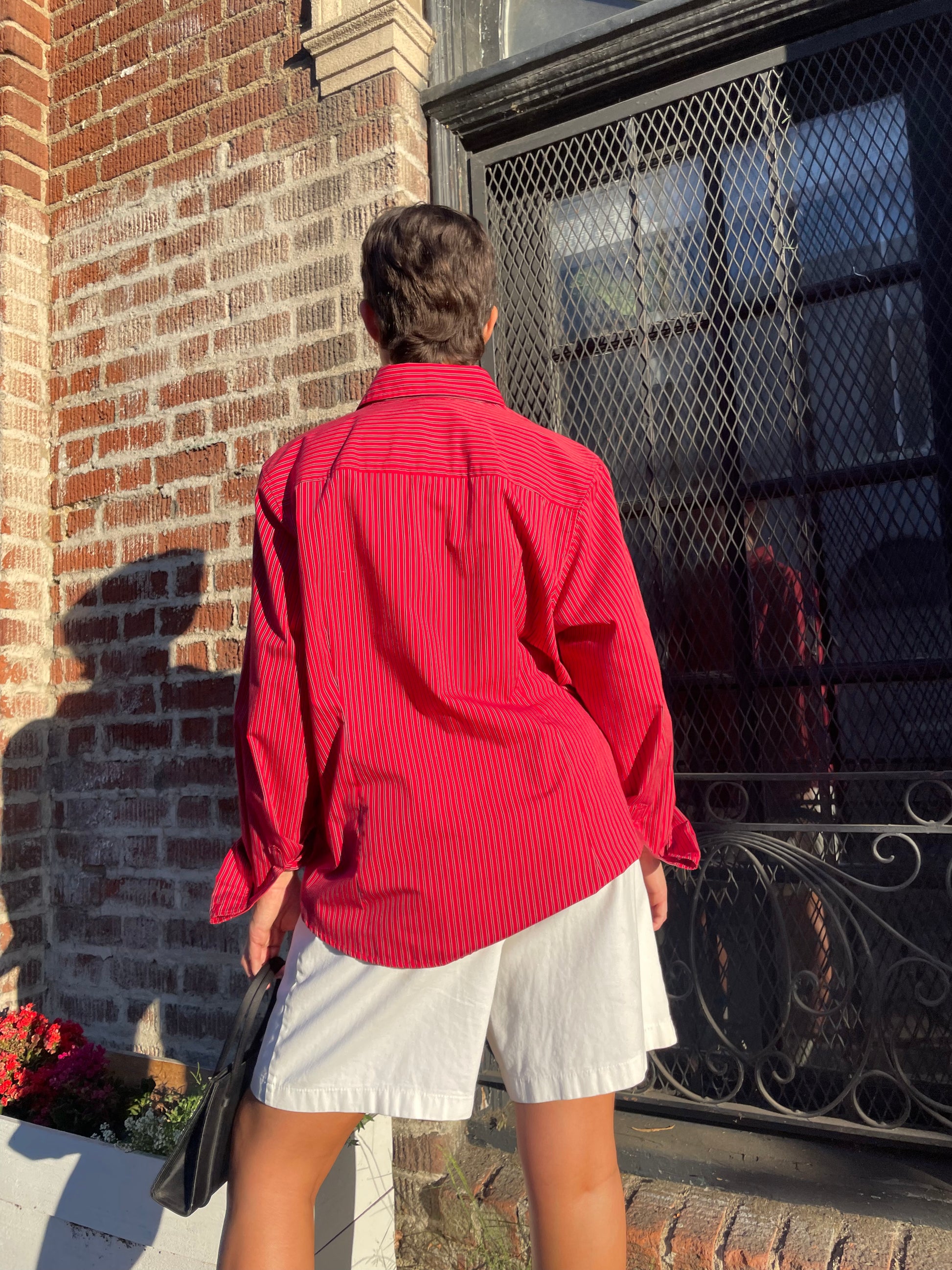 girl wearing red button down shirt and white shorts