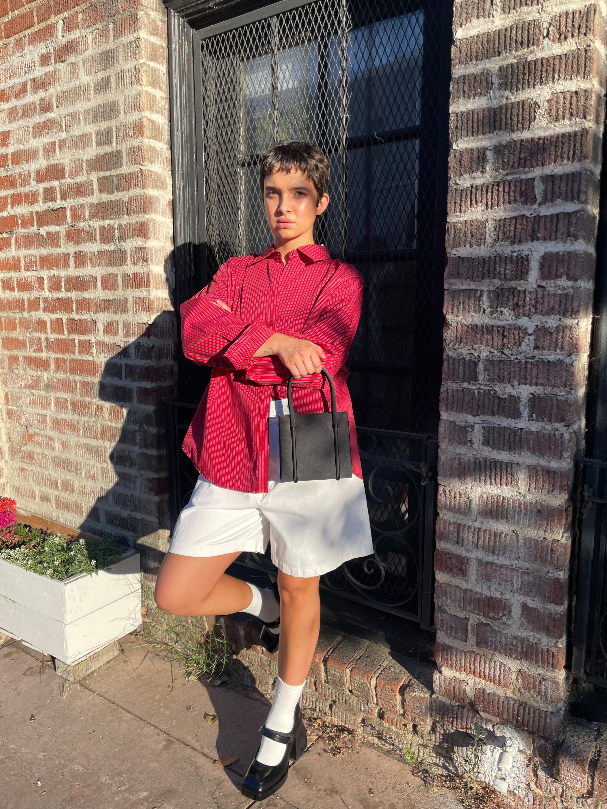 girl wearing red button down shirt and white shorts