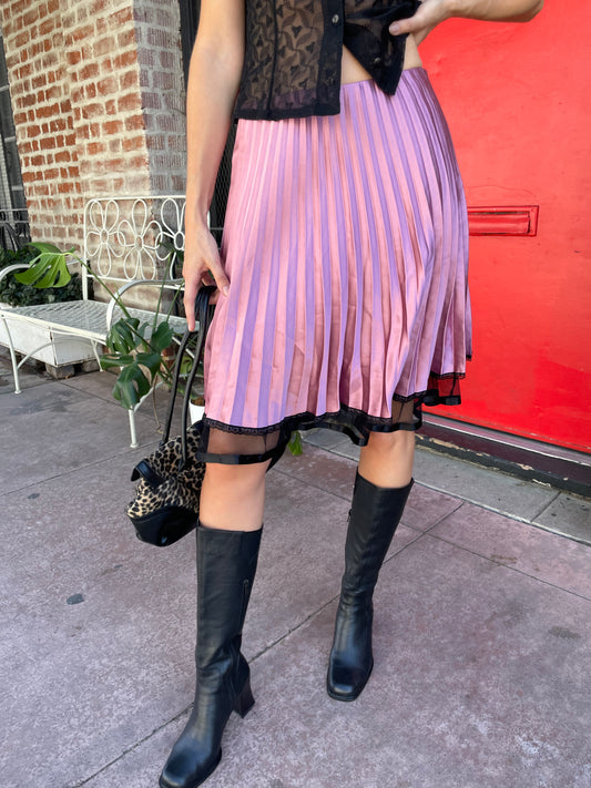 girl in pink satin pleated skirt and black top