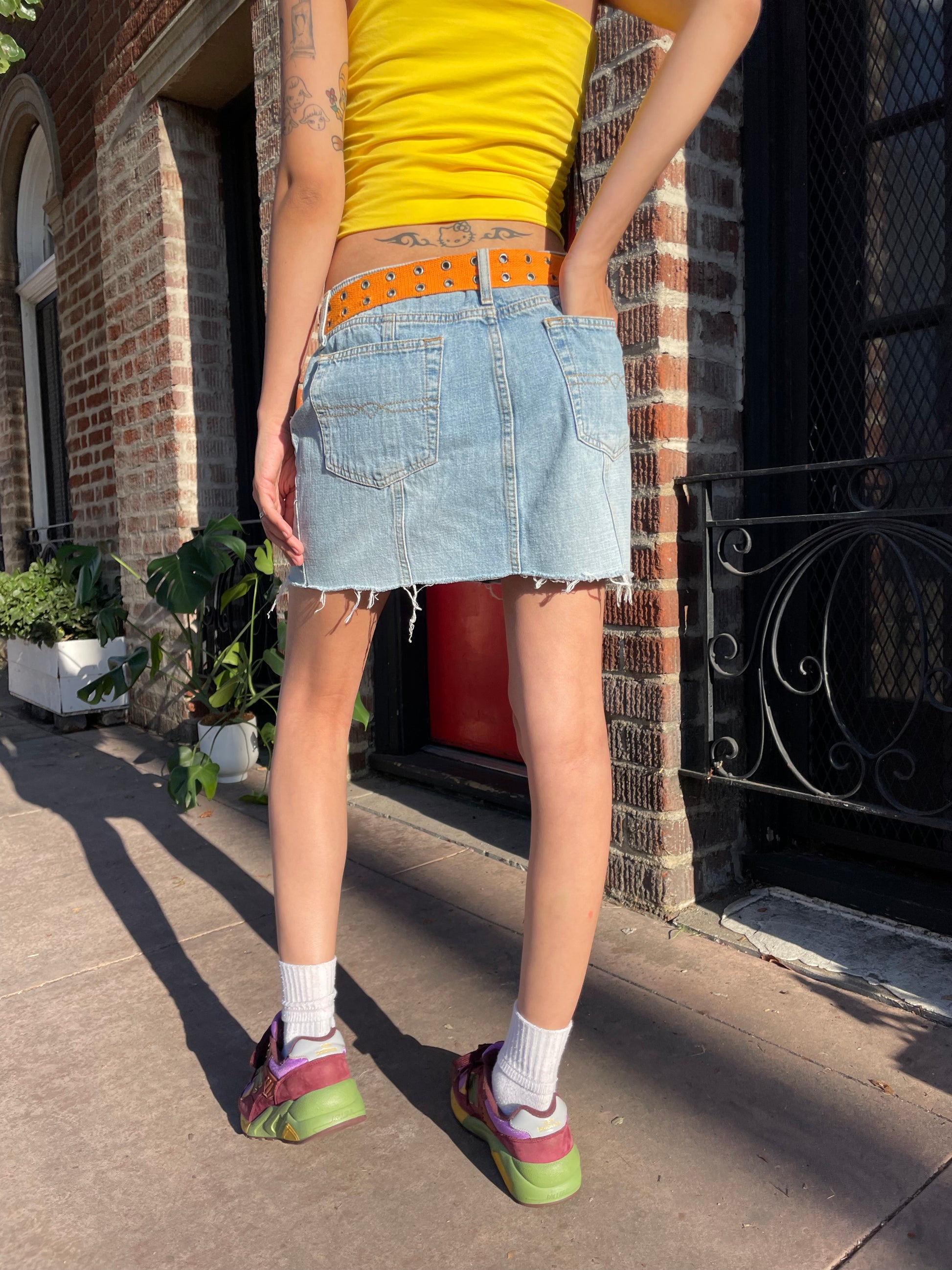 girl in yellow top and denim skirt