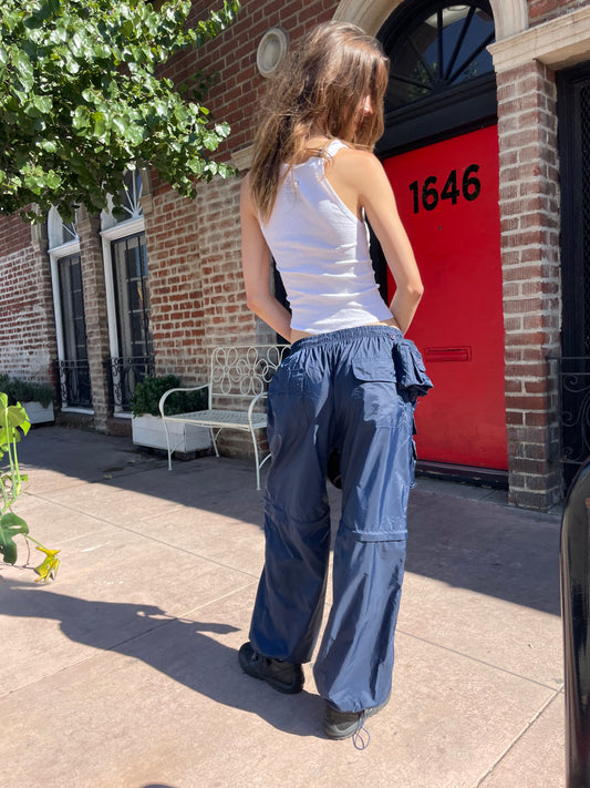 girl in white tank top and blue cargo pants