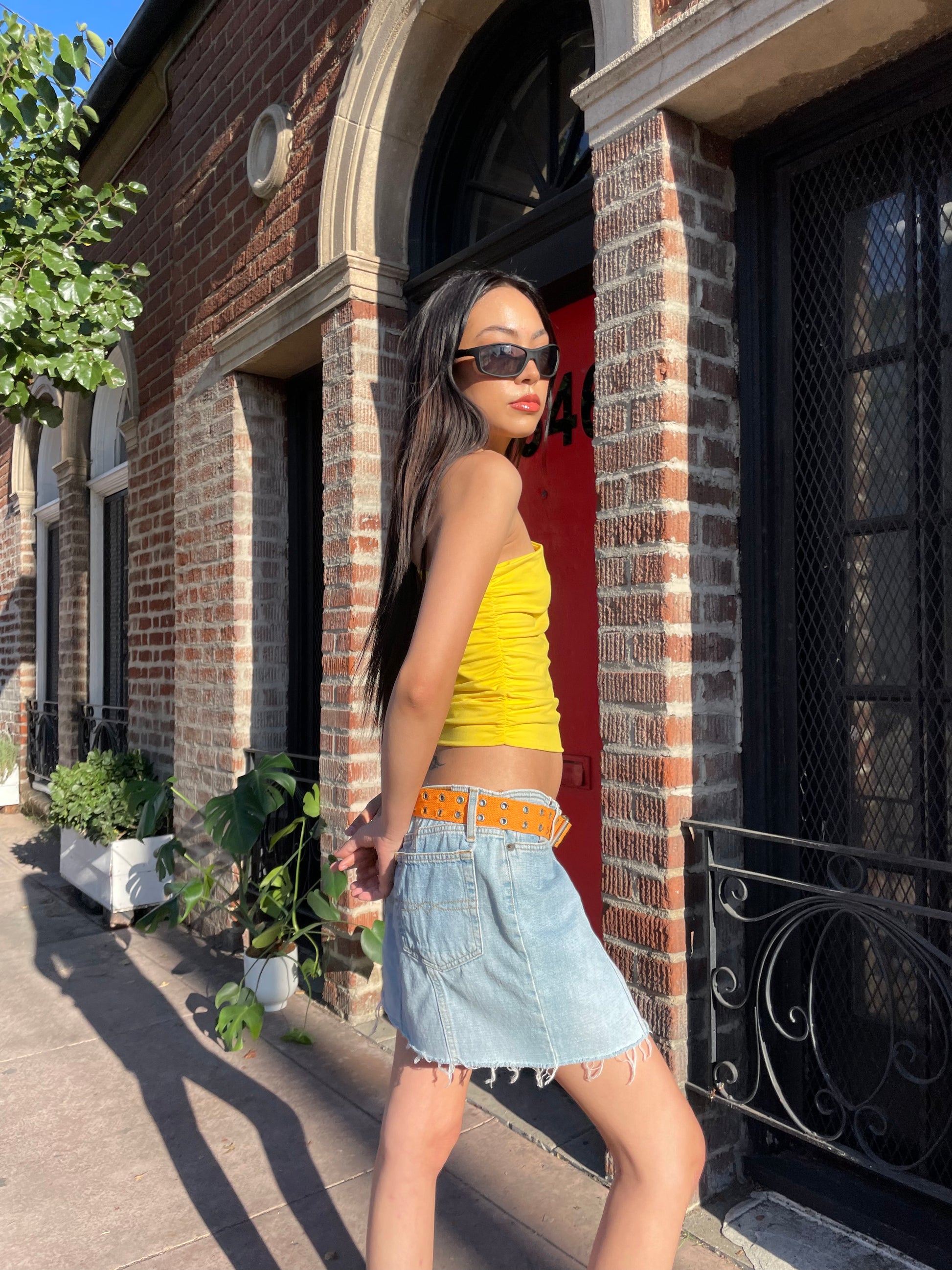 girl in yellow top and denim skirt