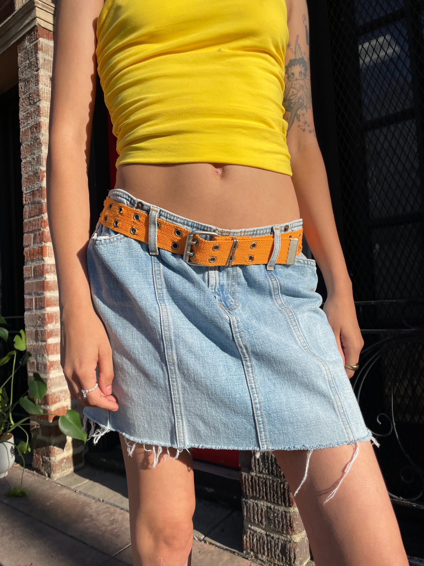 girl in yellow top and denim skirt