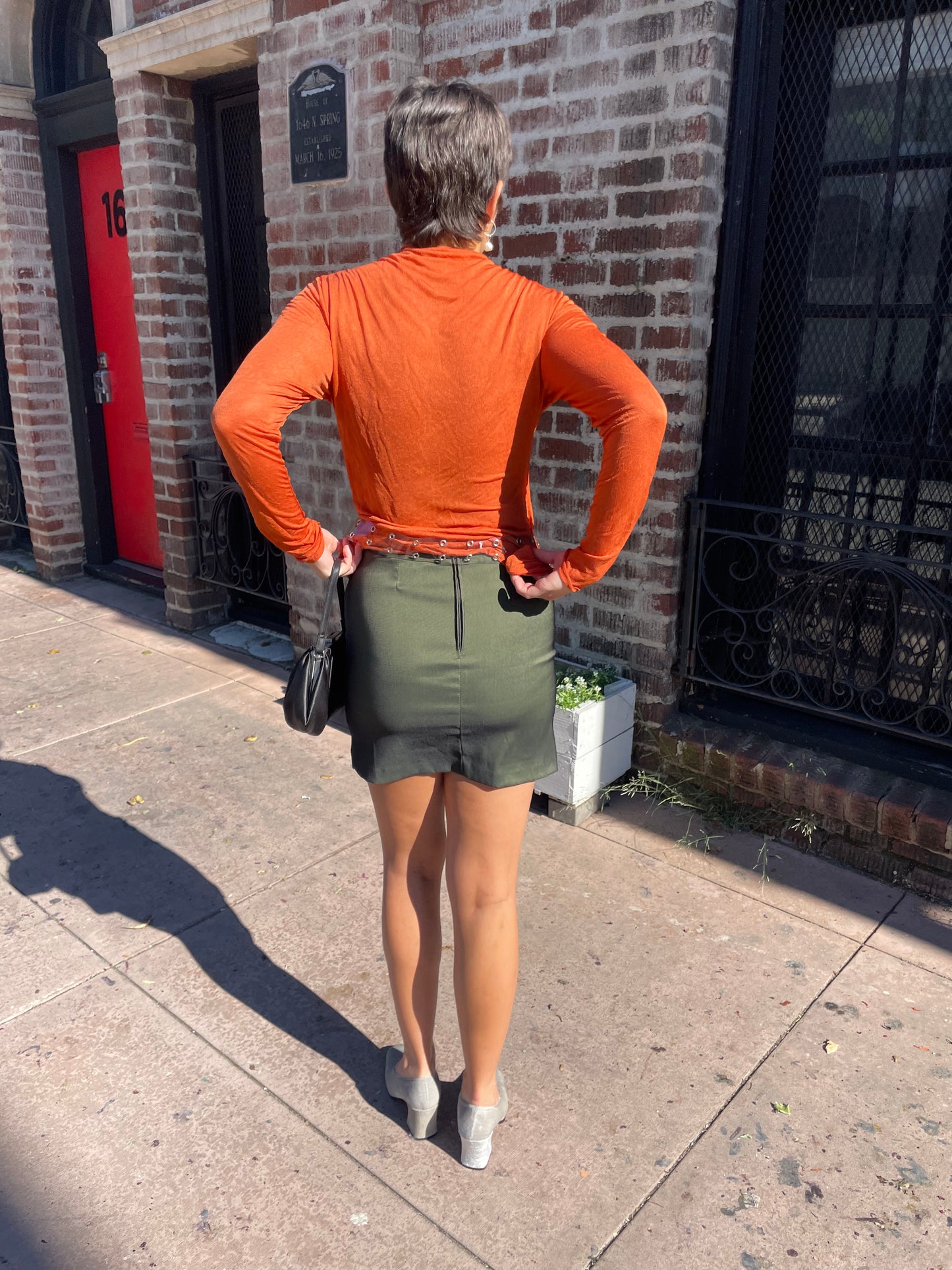 girl wearing green mini skirt and orange top