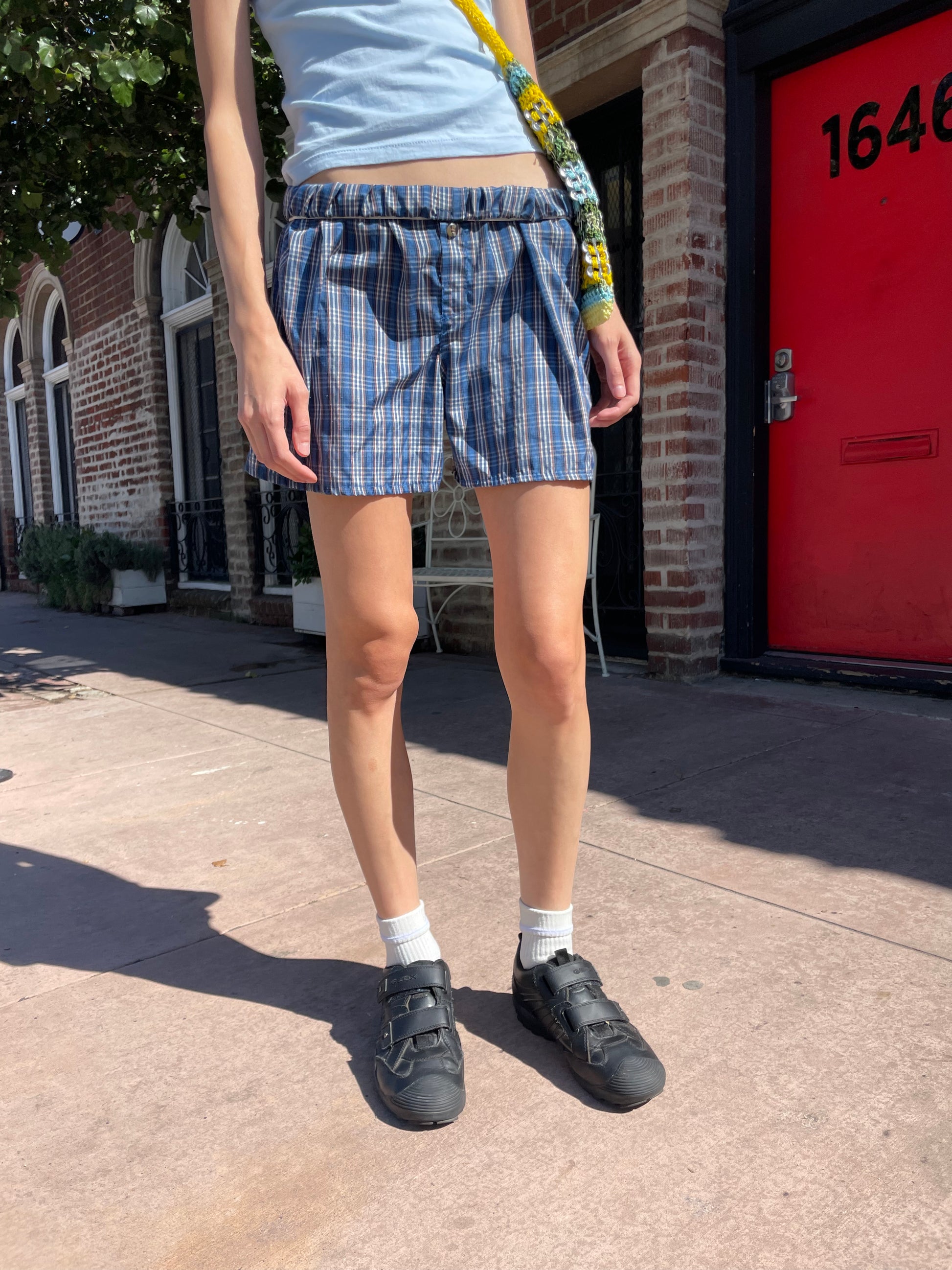 girl in blue t-shirt and plaid shorts