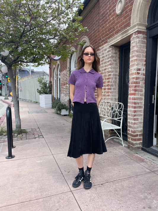 girl wearing purple button up top and long black skirt