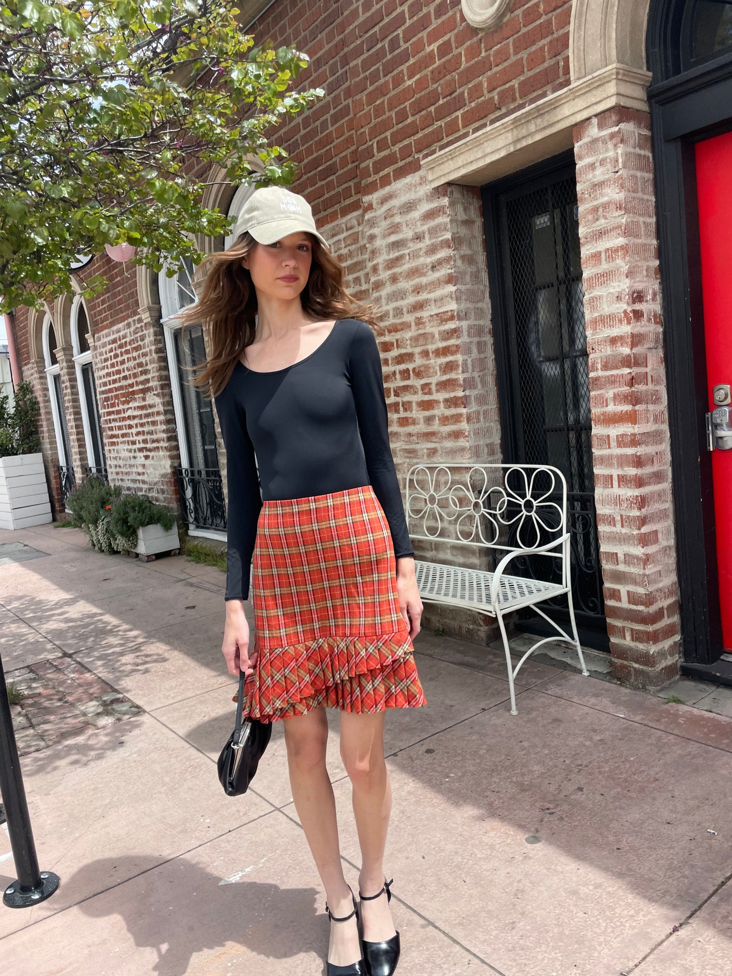 girl wearing black leotard and red plaid skirt