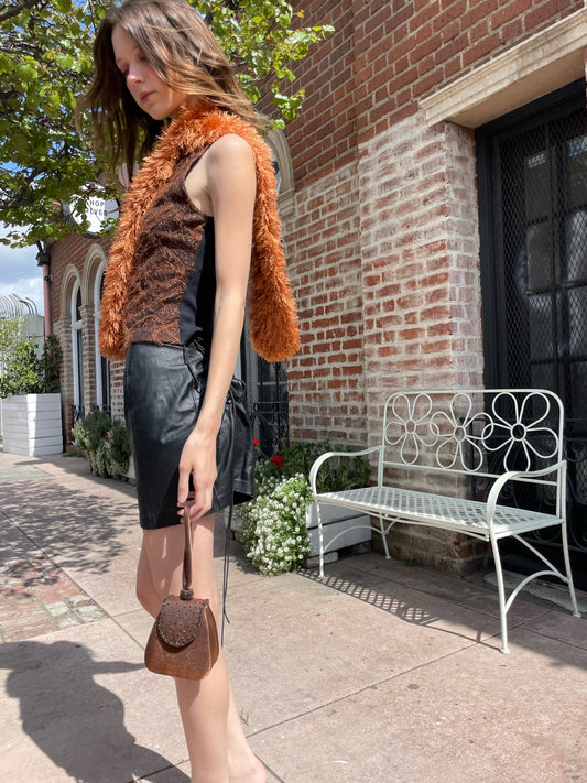 girl wearing brown textured tank top and leather mini skirt with a fuzzy brown scarf.