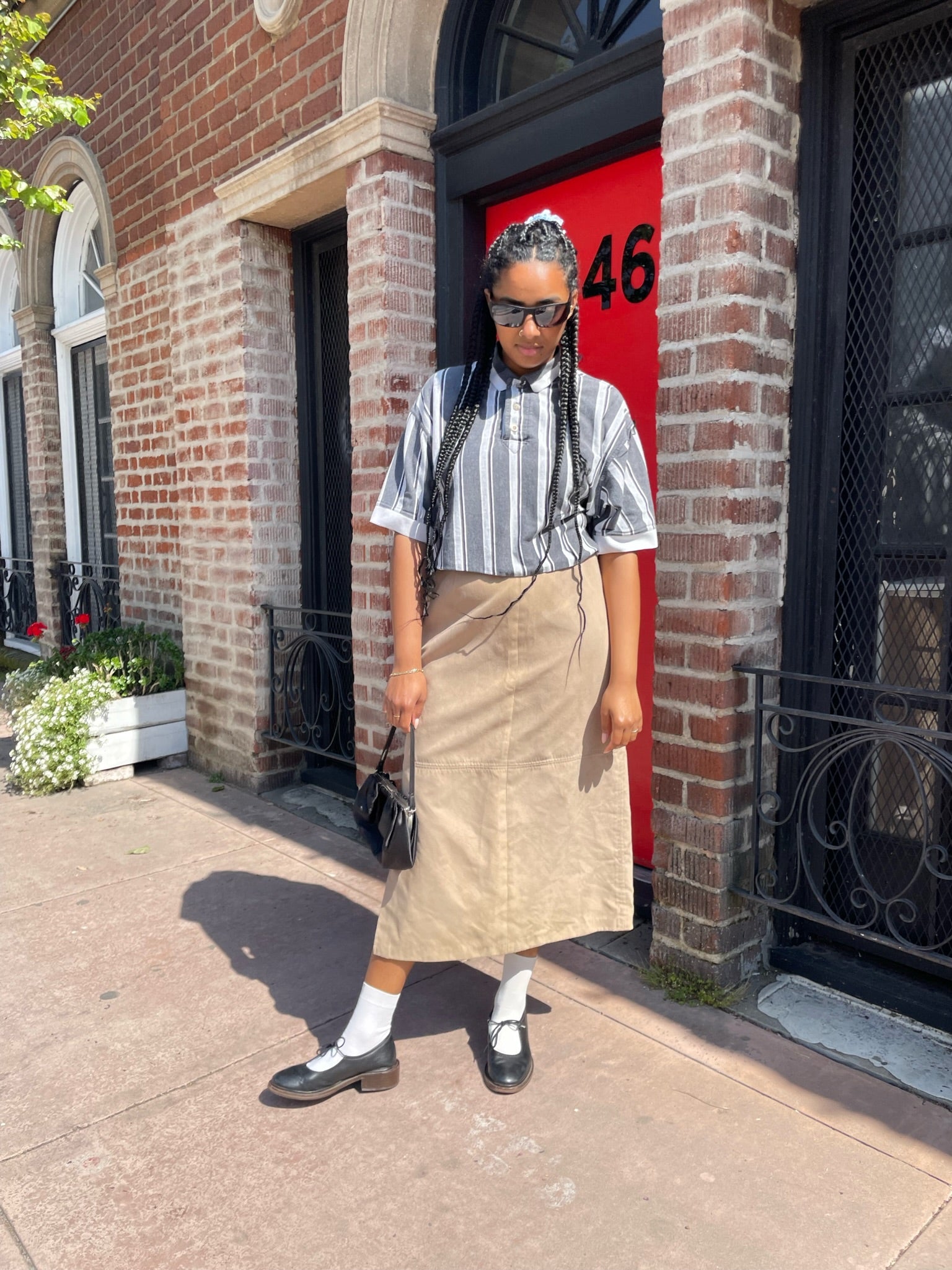 girl wearing black and white striped shirt and long tan skirt