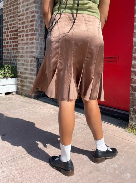 back of girl wearing green top and pink silk skirt