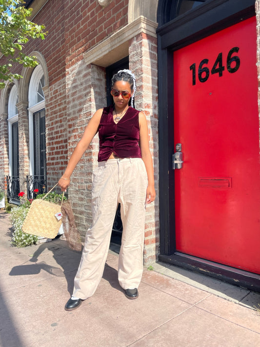 girl wearing red velvet vest and white pants