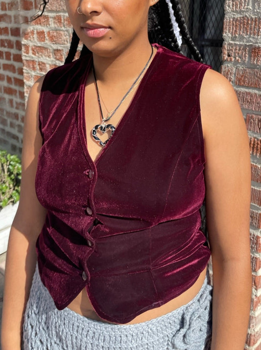 girl wearing red velvet vest and light blue crochet skirt