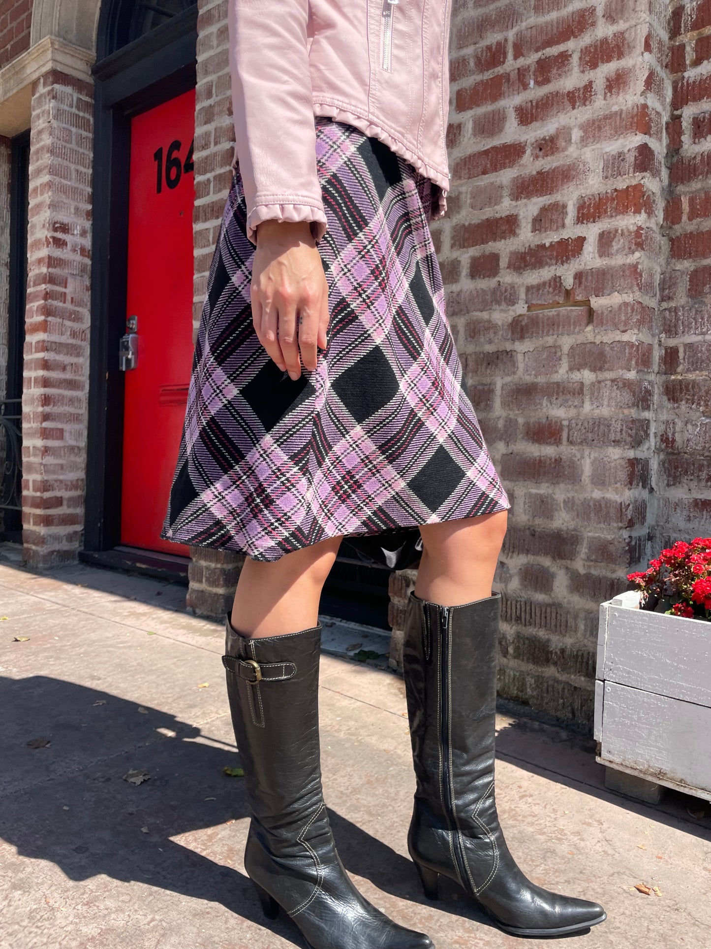 girl in plaid skirt and pink jacket