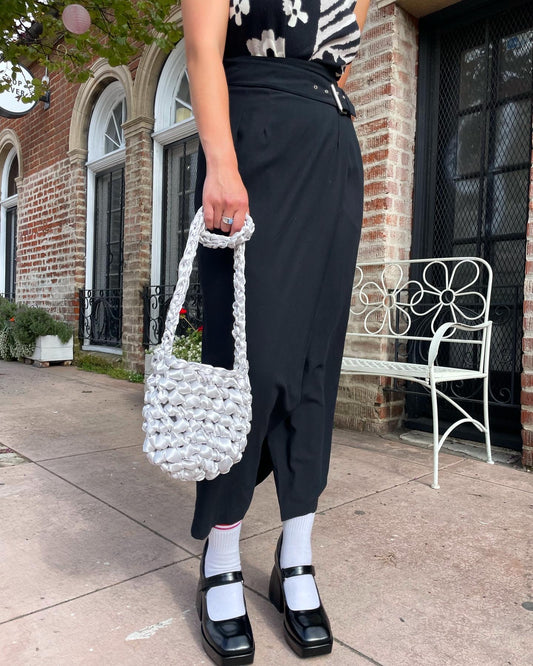 girl wearing black skirt and white purse