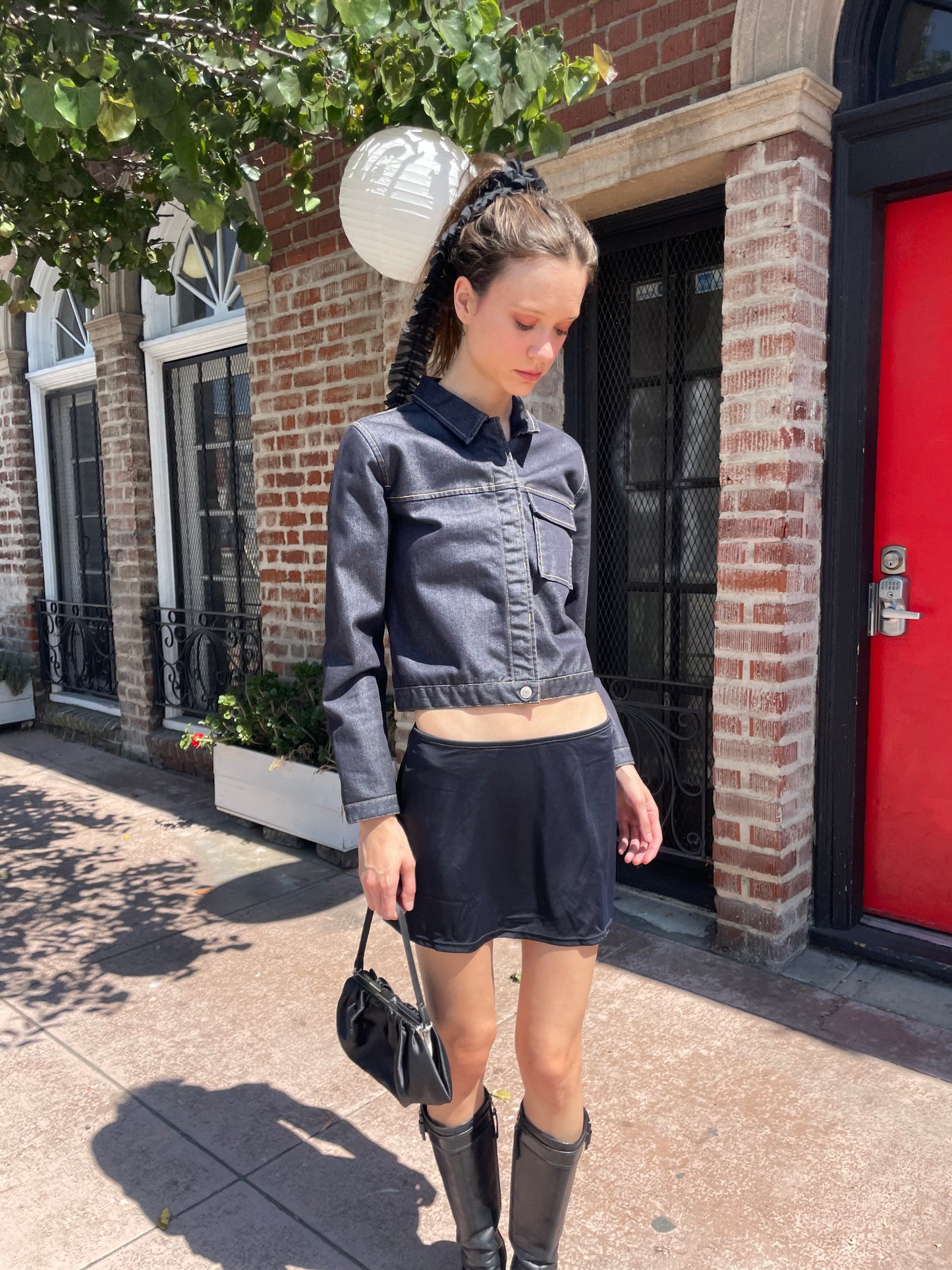 girl in denim jacket, black skirt and leather boots