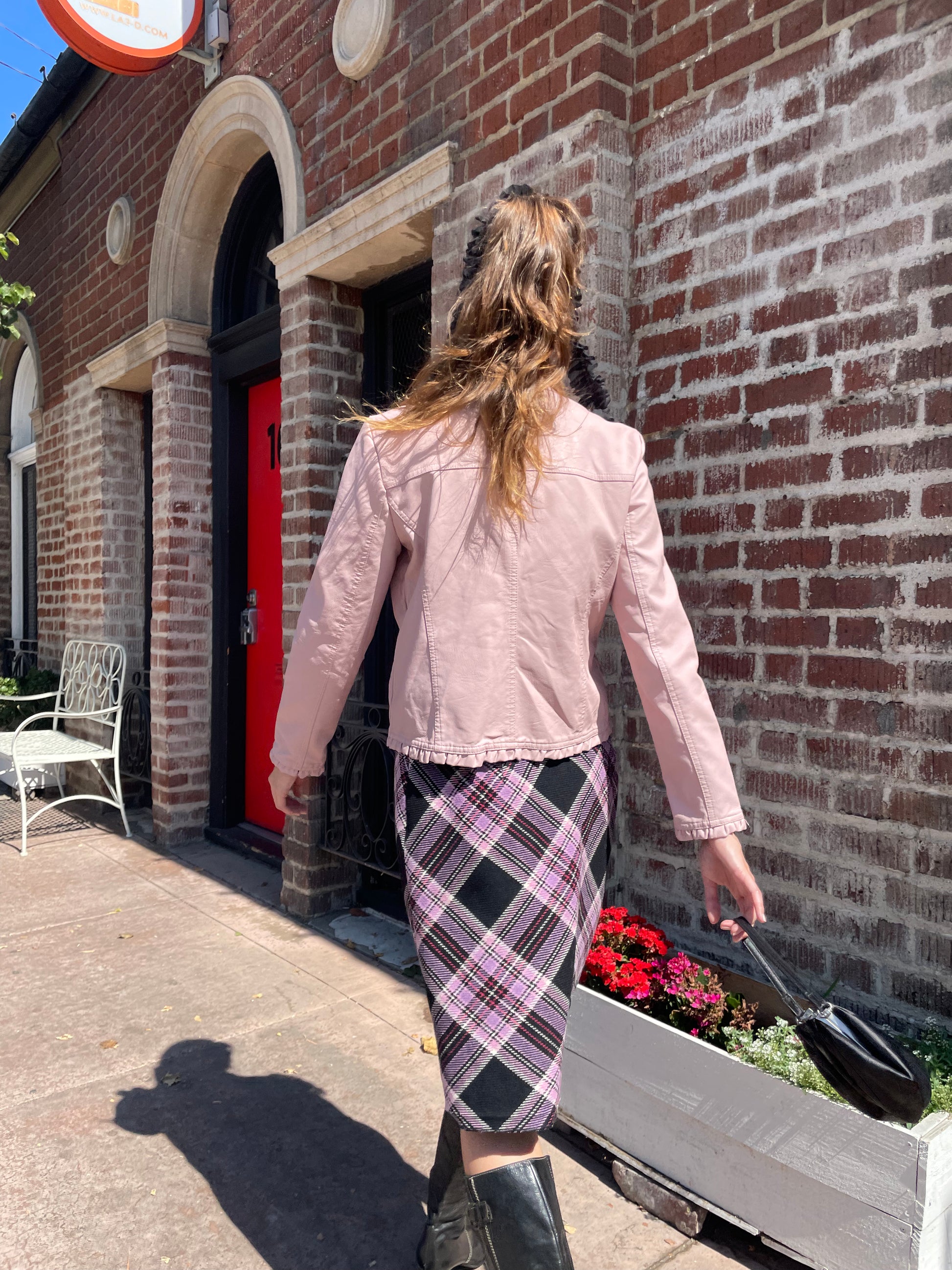 girl in plaid skirt and pink jacket