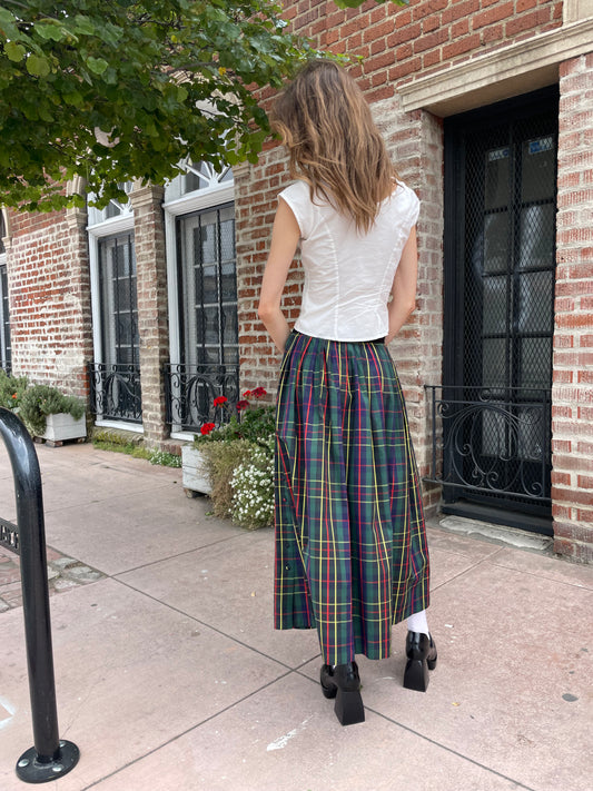 girl in green plaid skirt and white top