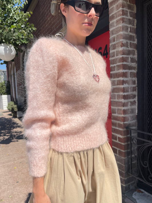 girl in tan skirt and light pink sweater
