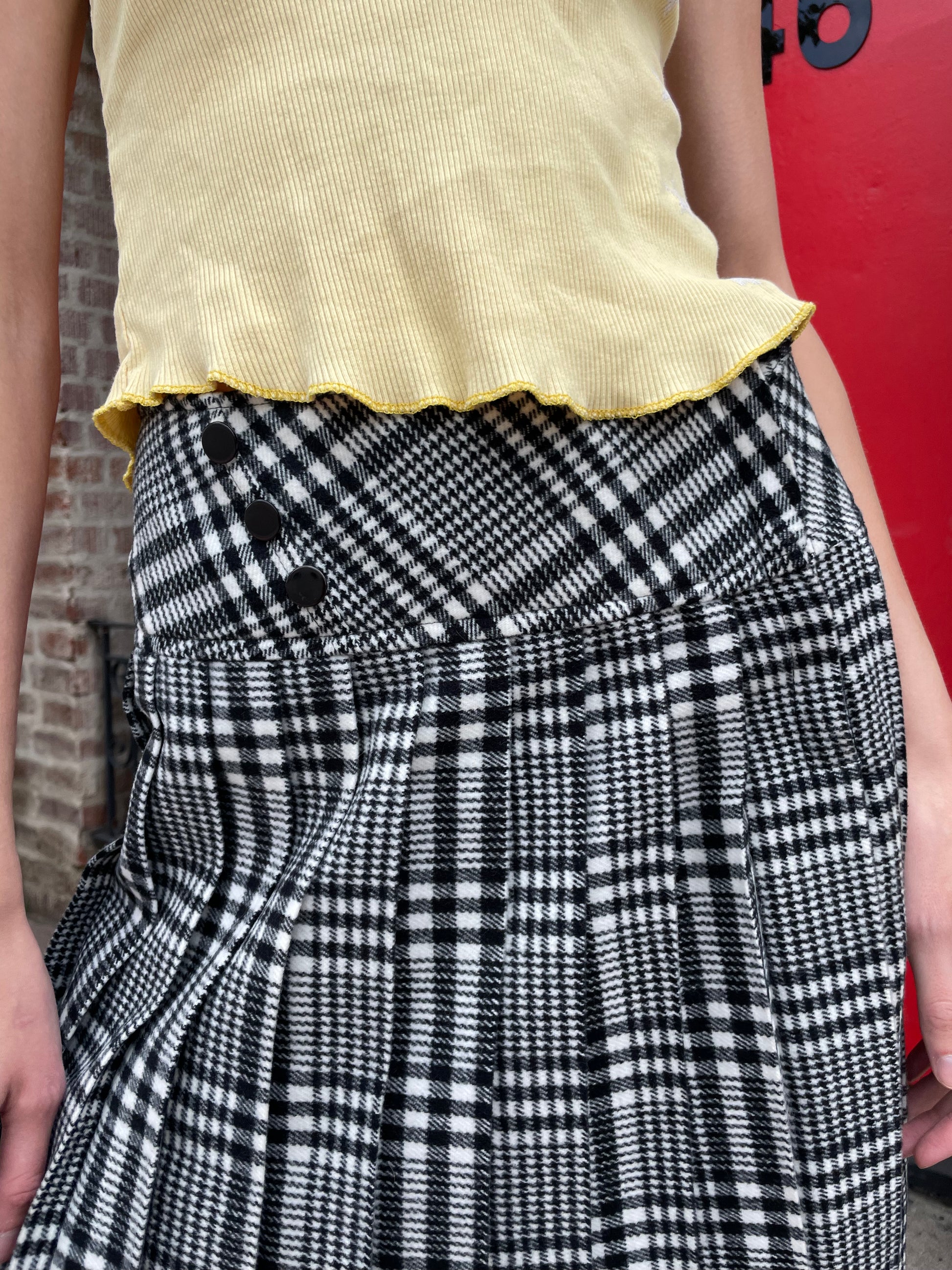 girl in yellow top and black and white skirt