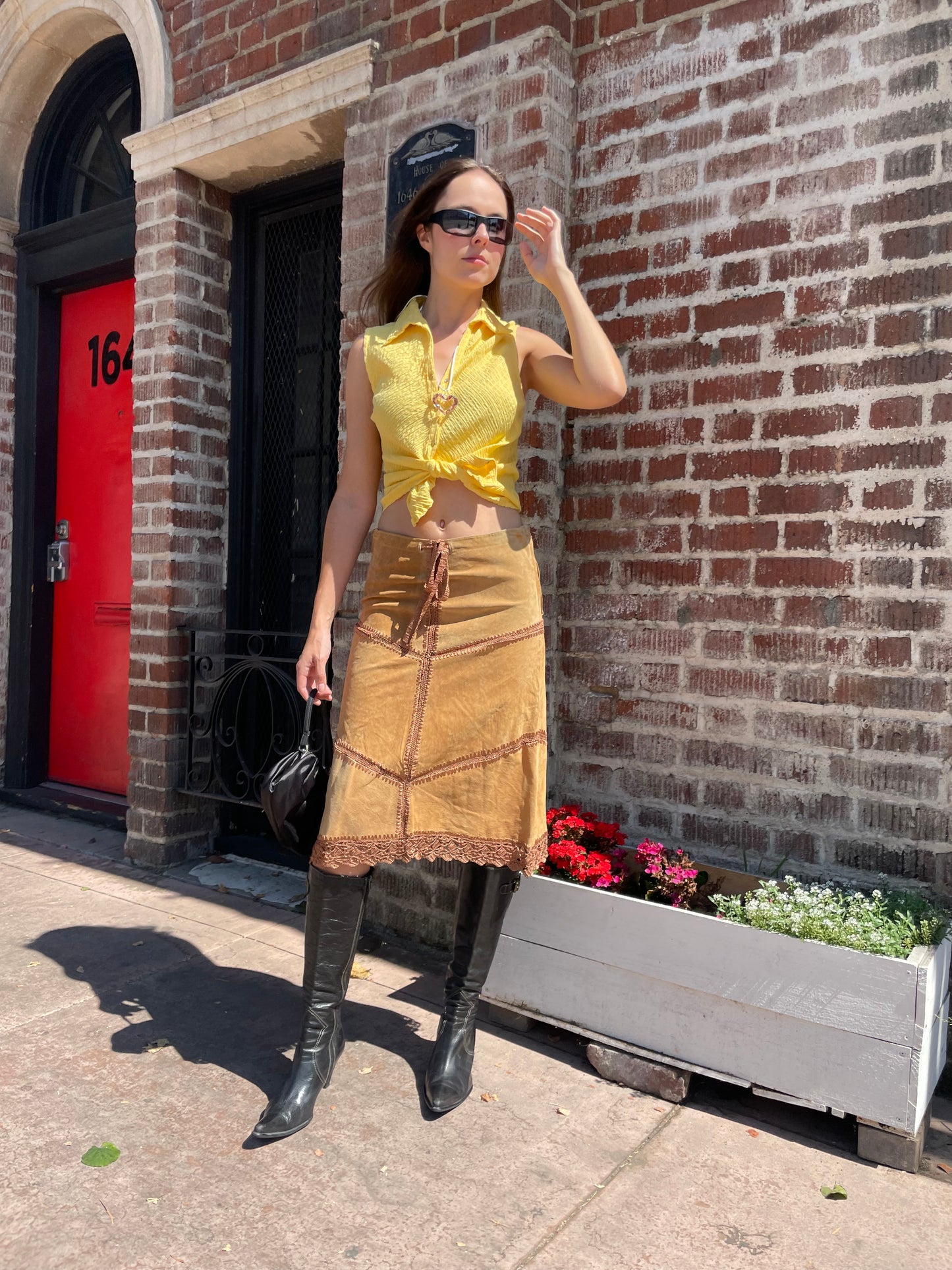 girl wearing tan leather skirt and yellow top