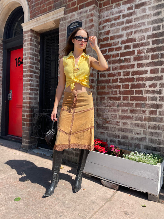 girl wearing tan leather skirt and yellow top