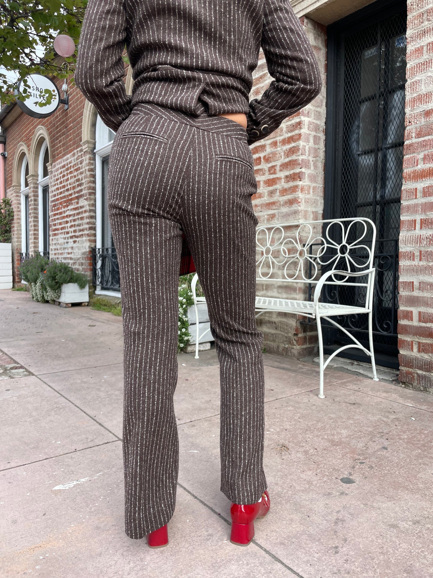 girl wearing brown blazer and slacks set with red plaid purse