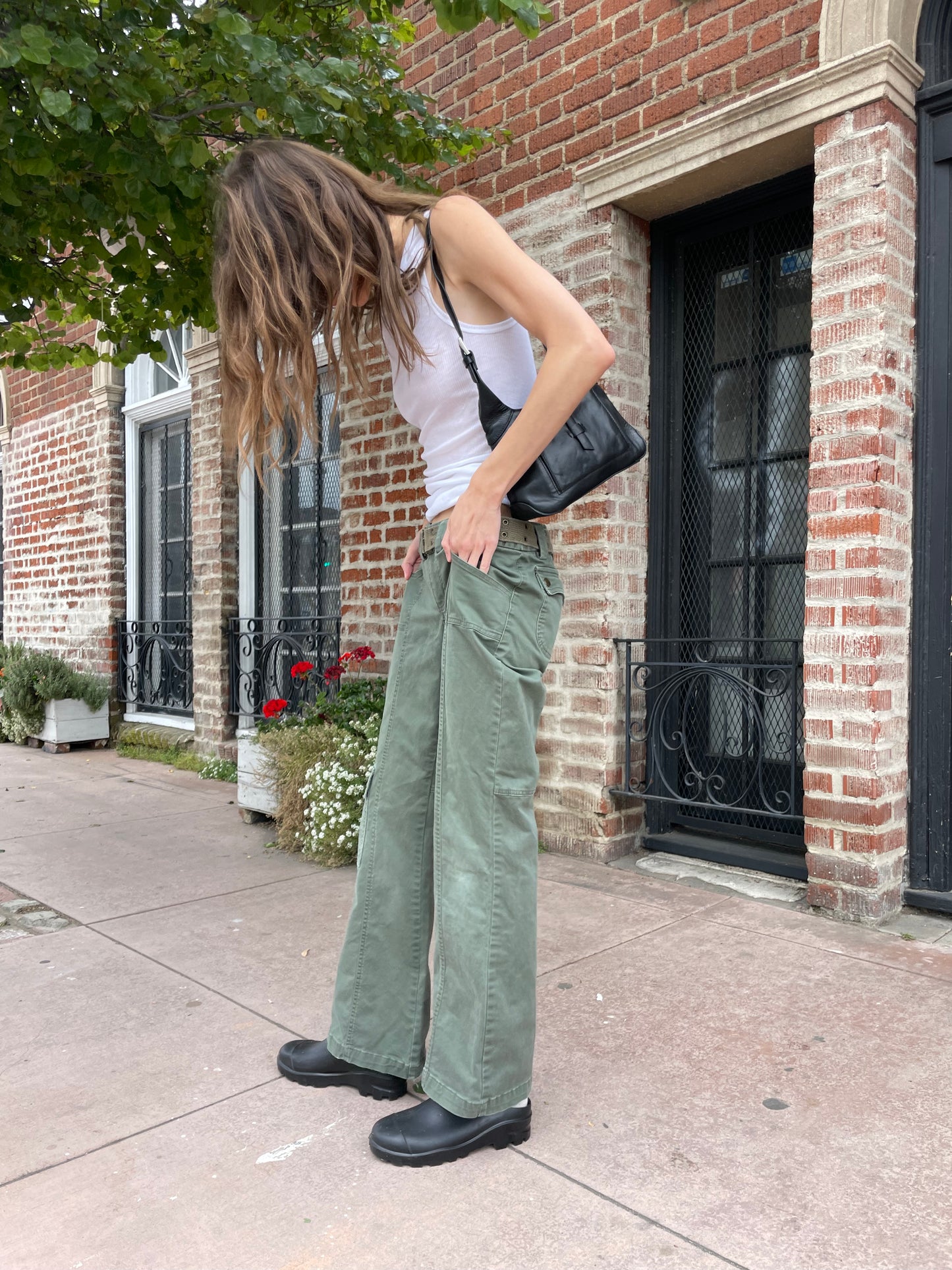 girl wearing white tank and green cargo pants