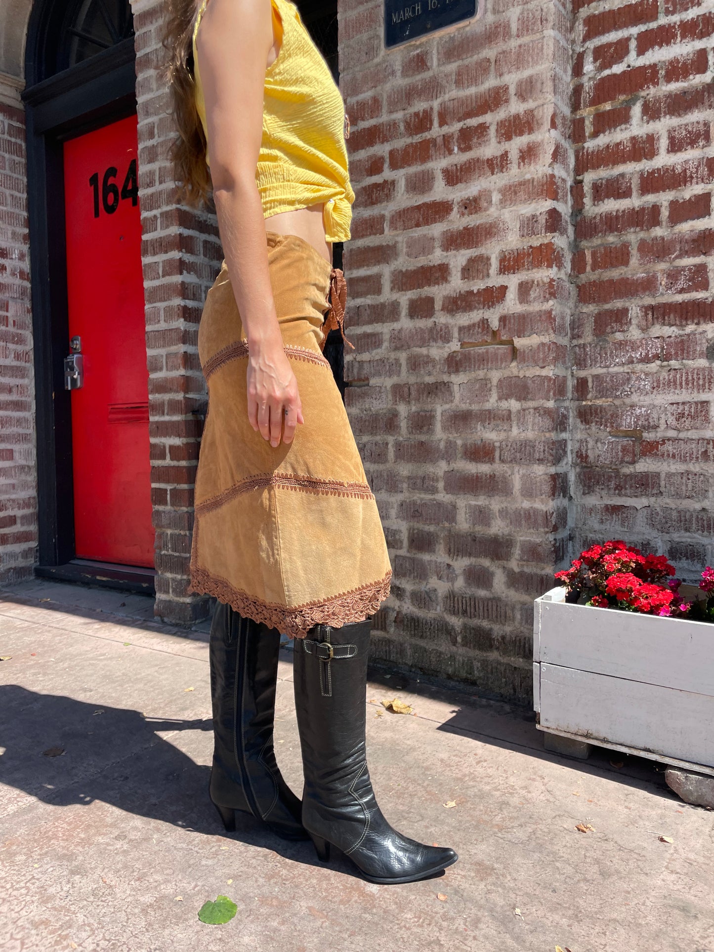 girl wearing tan leather skirt and yellow top