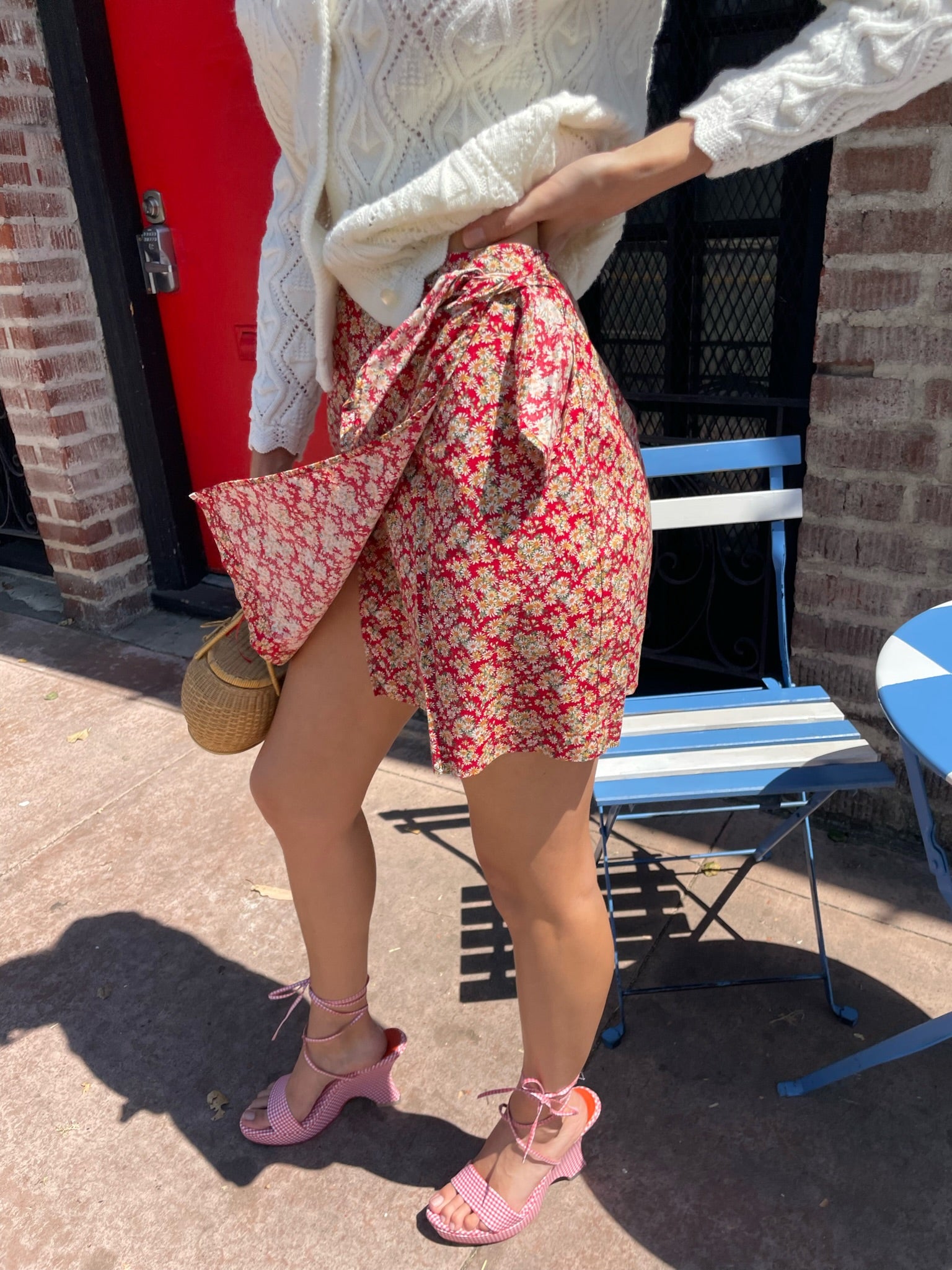 girl wearing red floral skirt and white cardigan